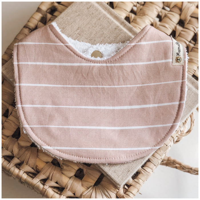 Baby bib in a soft dusty rose pink with thin horizontal white stripes, made from cotton with an absorbent towelling back.