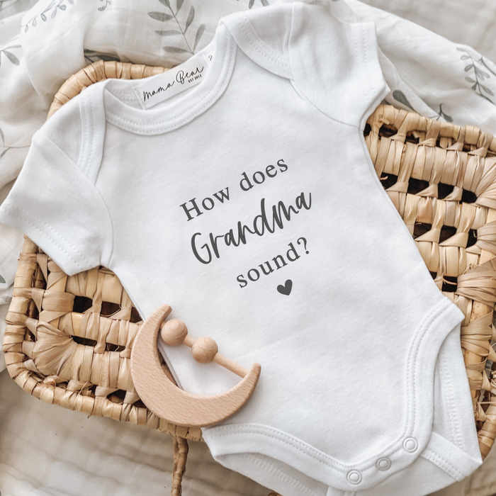 Baby announcement onesie with the text how does Grandma sound? on it in black