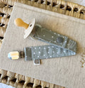A sage green material dummy clip with white spots and leaves.